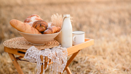 Composition from an assortment of fresh bread on a background of a mowed field of wheat.