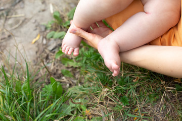 Fototapeta na wymiar a small child in the arms of M. the feet of a small child