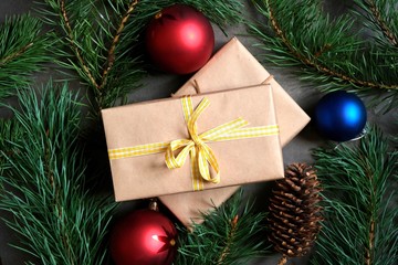 Christmas composition. Elegantly wrapped Christmas gifts on the background of Christmas tree branches and colorful toys.