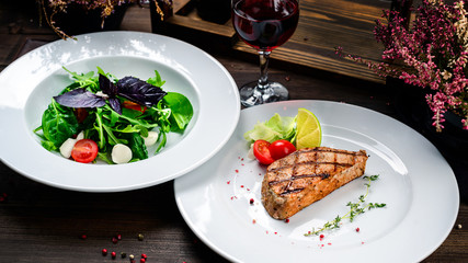 two plates of steak and salad on the table