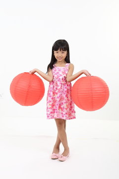 uth East Asian young girl child stand pose look at camera holding chinese red paper lantern on white background