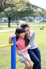 Fototapeta na wymiar South East Asian young Chinese mother daughter parent child play relax activity outdoor park smile love