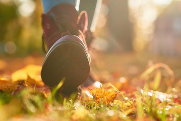 Female boots with a maple autumn leaves background