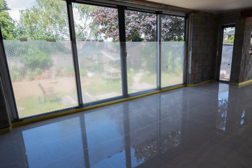 Installation of underfloor heating, last finishing stage, concrete over the layed pipes, protected windows, block walls in extension, selective focus