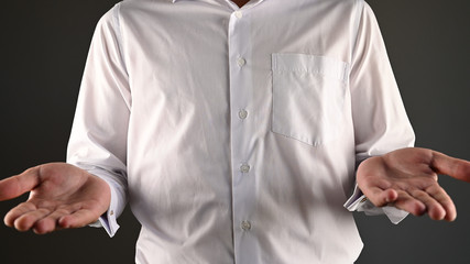 a man in a white shirt makes a helpless gesture