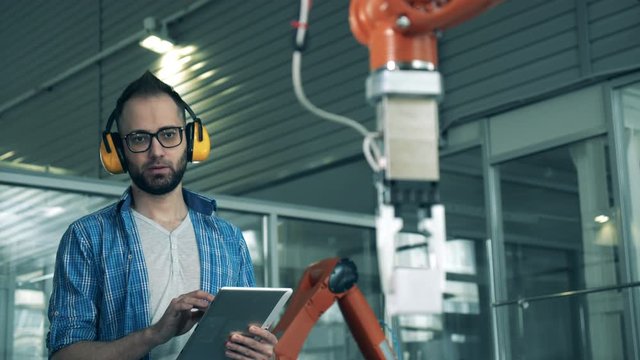 A man checks robotic machine moving cubes.
