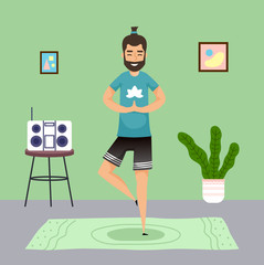Man practicing yoga at home. Meditation pose, young guy with ponytail meditate standing at one leg at carpet. Keep calm. Music center, houseplant, pictures at wall. Qurantine isolation. Stay at home