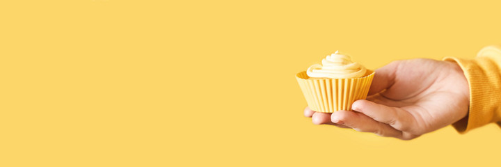 Yellow monochrome bakery. Sustainable cupcake cup. Hold in hand. Gold maffin cream. Trendy...