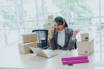 A beautiful businesswoman working at home is checking orders for products to be delivered to her...