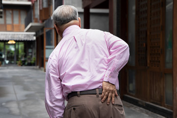 old Asian senior man suffering from herniated disc, spinal dislocation, lower back pain, gout...