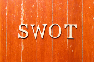 Alphabet letter in word swot (abbreviation of strength, weakness, opportunities, threats) on old red color wood plate background