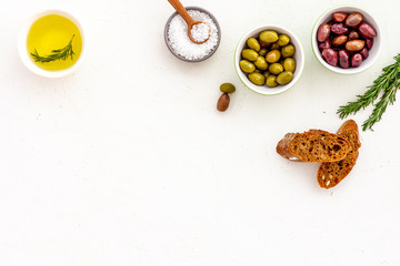 Top view of olives, olive oil, bread on yellow table top view copy space