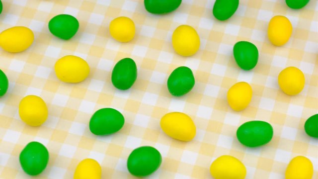 Candy sweets background. Assorted colorful chocolate candies. Yellow and green color palette delicious sweets turning.
