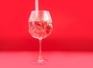 Bright juicy selected strawberries in a large glass with soda.