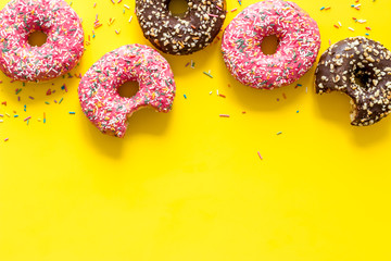 Colorful donuts pink and chocolate icing. Flat lay of bakery, above view