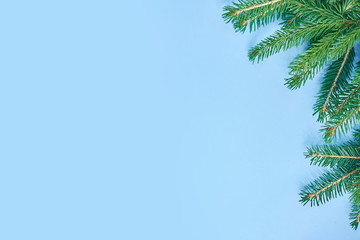 Obraz premium Christmas background with xmas tree on blue canvas background. Merry christmas card. Winter holiday theme. Happy New Year. Space for text. christmas backdrop top view. Flat lay.