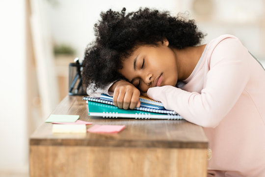 Teen Girl Sleeping During Class Resting Head On Books Indoors