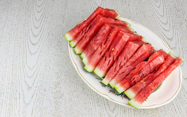 The sliced watermelon lies on an oval plate.