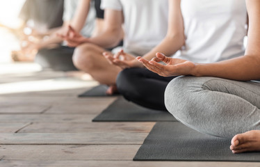 Group Of Unrecognizable People Meditating In Lotus Position And Showing Mudra Gestures