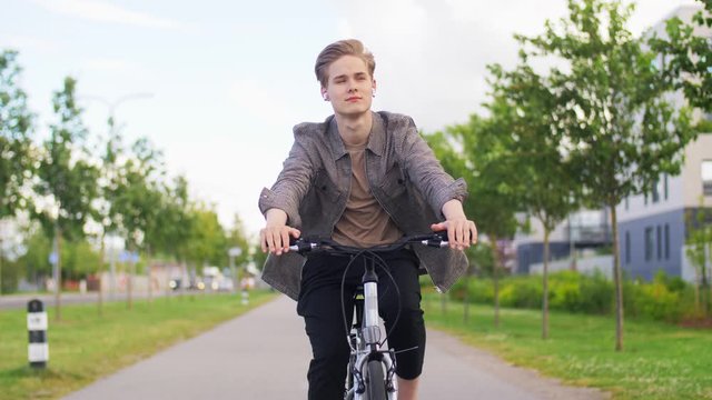 lifestyle, transport and people concept - young man or teenage boy riding bicycle on city street