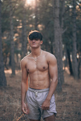 Foto en medio de un bosque con un joven musculoso 