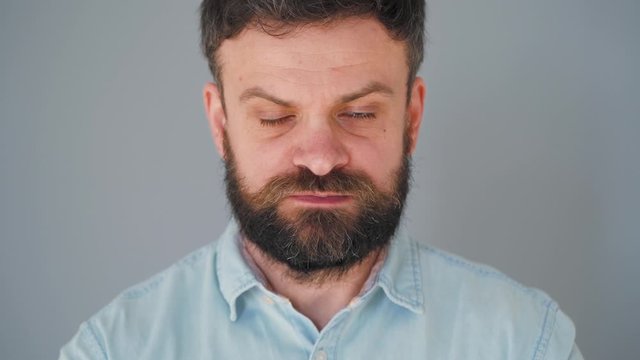 Bearded man chewing chewing gum. Man blowing out a bubble of bubble gum