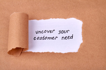 Uncover your customer need concept. Uncovered beige paper and revealed marketing slogan.