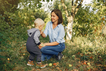 Fototapeta premium Fashionable mother with son. Family in a spring park. Woman in a blue shirt