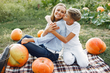 Family in a garden. People with pumpkins. Woman in a blue shirt