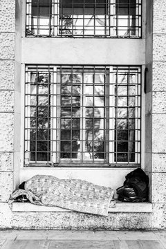 Senza tetto dorme sotto una finestra dell'EUR a Roma Italia