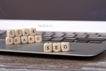 Search engine optimization concept. Wooden block cube shape with word seo and laptop on the wooden...