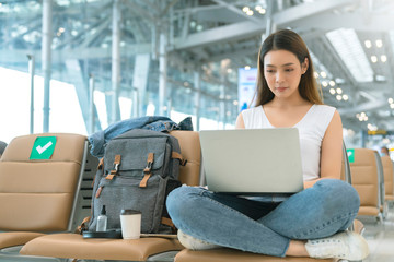 attractive asian female casual cloth with backpack  traveller relax sit wait in social distancing...