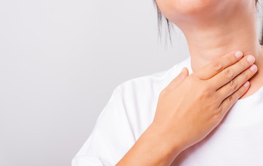 Fototapeta na wymiar Asian beautiful woman Sore Throat or thyroid gland problem her useing Hand Touching Ill Neck on white background with copy space, Medical and Healthcare concept