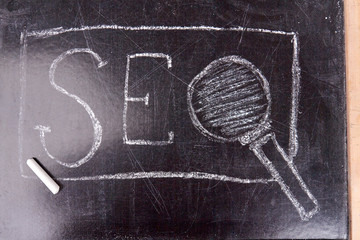 Fototapeta na wymiar Abbreviation seo written on the blackboard. White chalk on the school board. Search engine optimization concept.