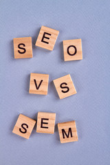 Seo vs sem concept. Letters written on wood block isolated on gray background. Web marketing symbols. Search engine optimization abbreviation.