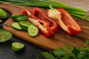 Sliced Cucumber with Green Vegetables on Rustic Cutting Board