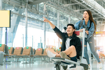 attractive Young Asian tourist couple excited together for the trip boyfriend sitting and cheering...