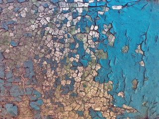 The old cracked paint on a wall surface. Peeling paint on iron background