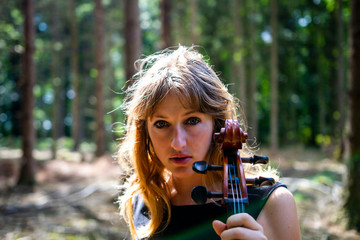 Woman with cello in the woods