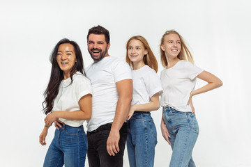 Obraz premium Group of adorable multiethnic friends having fun isolated over white studio background. Copyspace. Diversity, inclusion, friendship and love concept. Different nationalities united with sincere