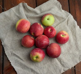 bunch of red ripe apples lies on a gray linen napkin