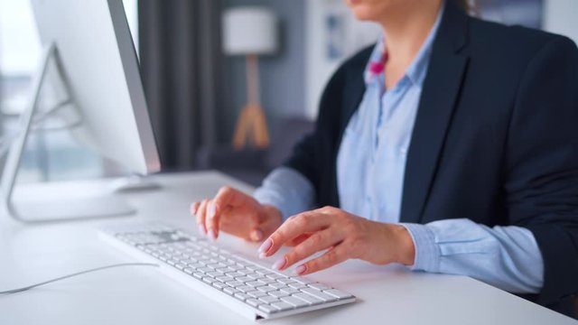 Woman in glasses typing on a computer keyboard. Concept of remote work.