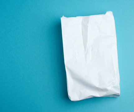 paper disposable food bag on a blue background, concept of delivery and ordering food