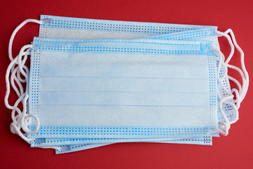 blue disposable medical mask on a red background