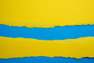 abstract background with torn edges of yellow paper, blue backdrop