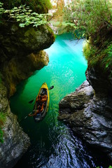 The Cascata della Soffia situated in the heart of Dolomiti Bellunesi National Park, Veneto, Italy. The Lago del Mis. Men sailing kayaking on the clear water of lake. © Travel Photos