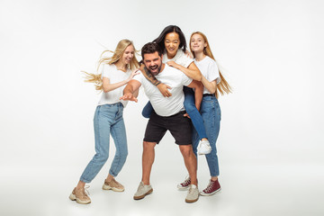 Fototapeta premium Group of adorable multiethnic friends having fun isolated over white studio background. Copyspace. Diversity, inclusion, friendship and love concept. Different nationalities united with sincere