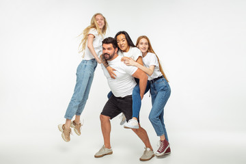 Group of adorable multiethnic friends having fun isolated over white studio background. Copyspace. Diversity, inclusion, friendship and love concept. Different nationalities united with sincere