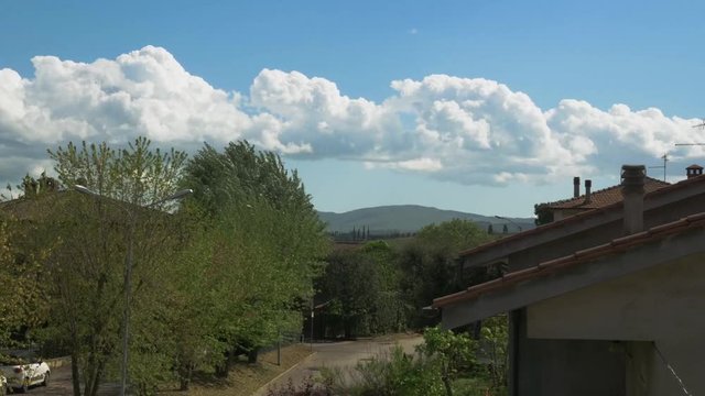 Nice shape clouds running on sky, in a Tuscany town. Montepulciano. Clouds background
