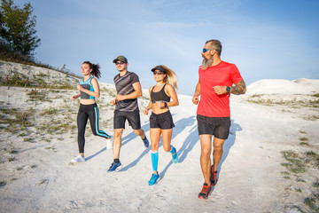 Four fitness runners jogging outdoors in desert